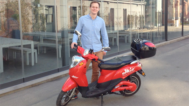 Valerian Seither, einer der eMio-Gründer, und ein knallroter E-Roller auf dem EUREF-Campus.